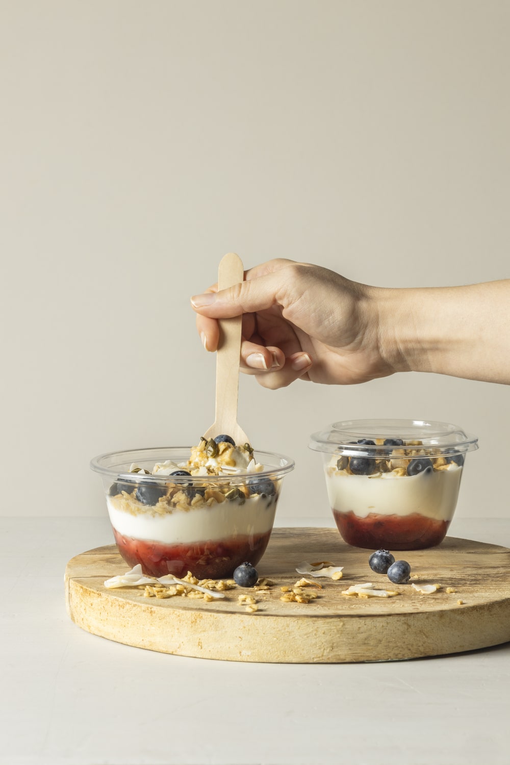 Takeout Goods Packaging's dessert cups and lids on display with layered yoghurt puddings and topped with blueberries.