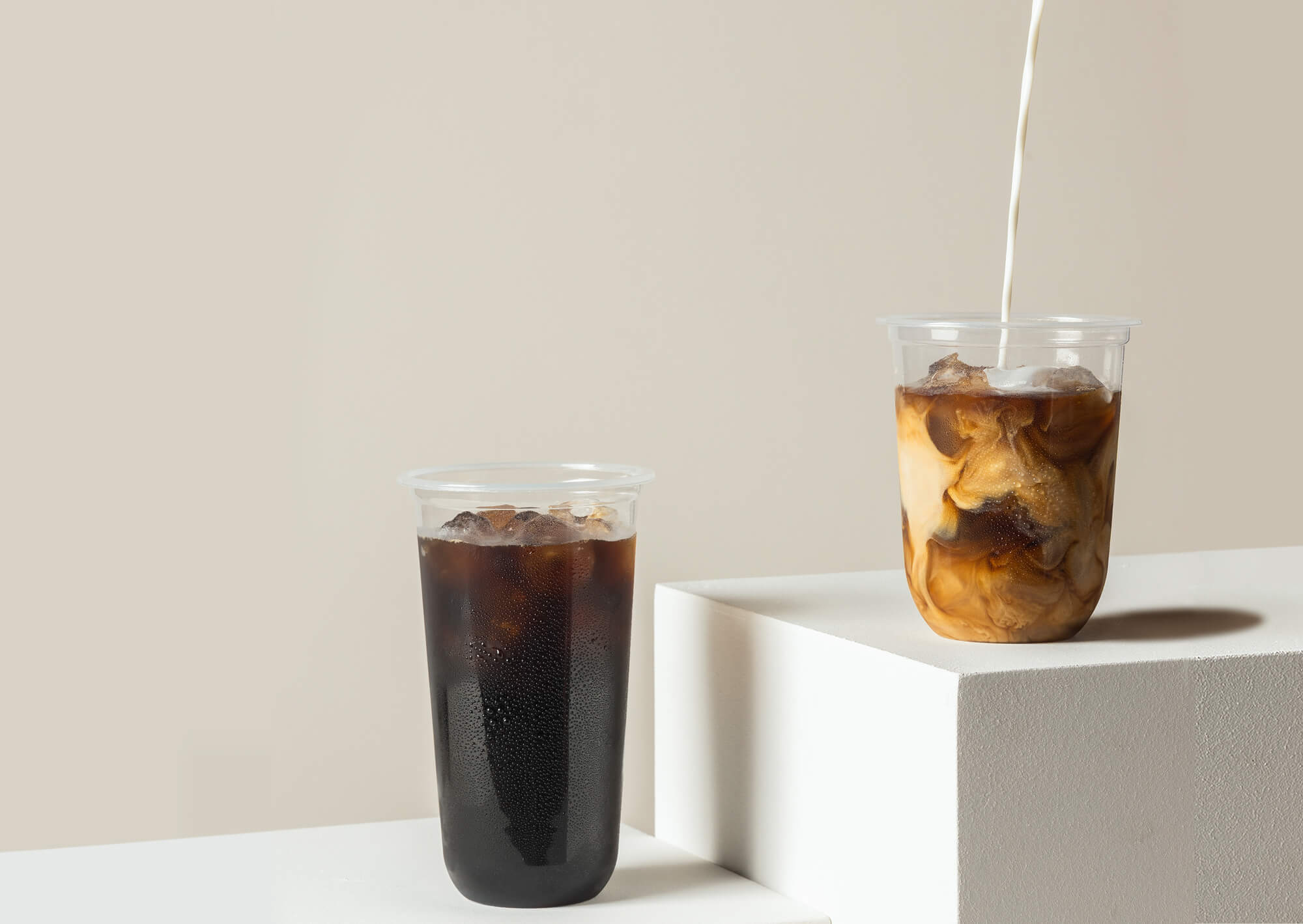 Pedestal display of innovative Takeout Goods Packaging cups filled with iced coffee.